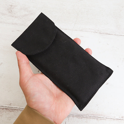 Black cotton sleeve pouch in hand for size scale