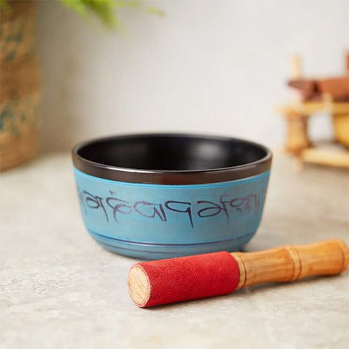 blue Khudi singing bowl with stick grey backdrop