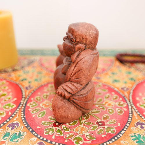 Wooden laughing Buddha figurine, side view religious ornament