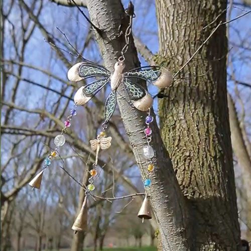 Handmade Indian dragonfly windchime hanging on a tree in a park